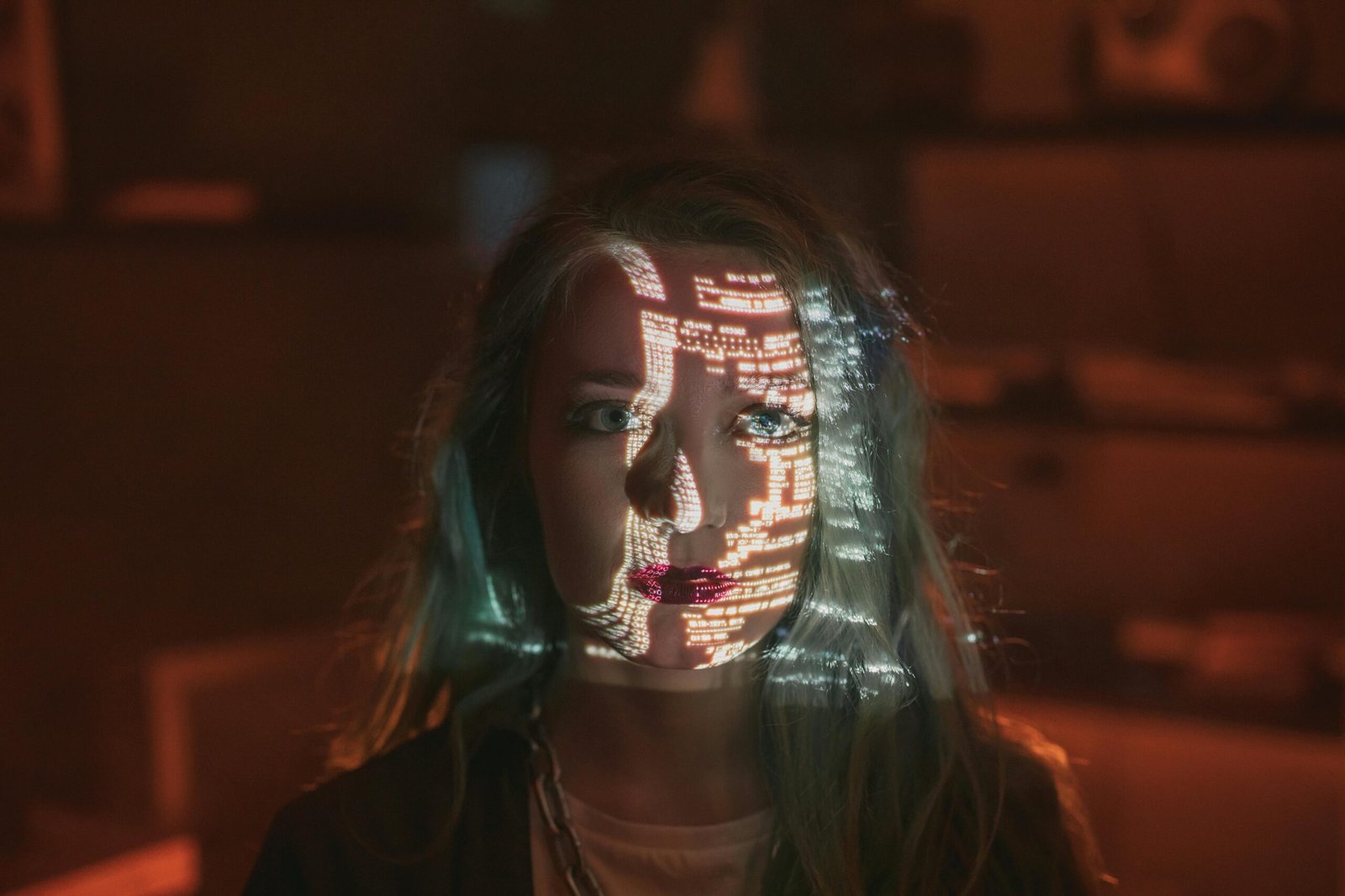 A woman's face illuminated by projected code, symbolizing cybersecurity and technology.